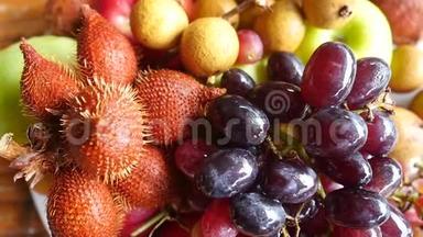 美味可口的热带水果放在木桌上的碗里。 最高的视野。 慢动作。 1920x1080